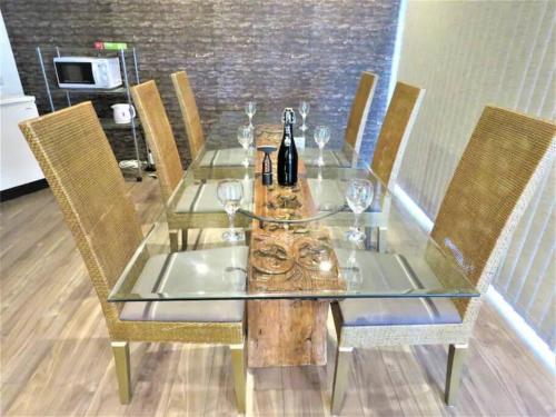 a dining table with wine bottles and glasses on it at BBQ無料 オーシャンビュー ジャグジー付1棟をまるまる貸切 2階建3LDK 無料駐車場4台 サファイアリゾートokinawa in Nanjo