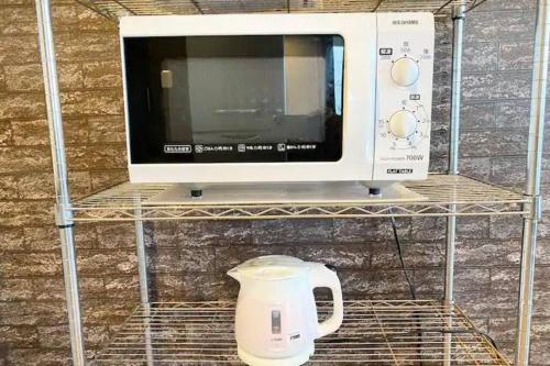 a microwave sitting on a shelf next to a appliance at BBQ無料 オーシャンビュー ジャグジー付1棟をまるまる貸切 2階建3LDK 無料駐車場4台 サファイアリゾートokinawa in Nanjo