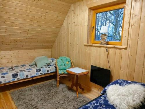 Habitación con cama, escritorio y ventana. en BIJAKÓWKA en Ustrzyki Dolne