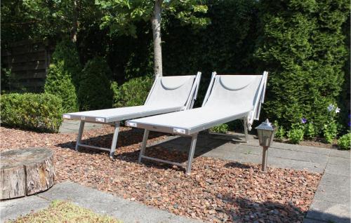 two white benches sitting next to a tree stump at Amazing Home In Grou With Wifi in Grou
