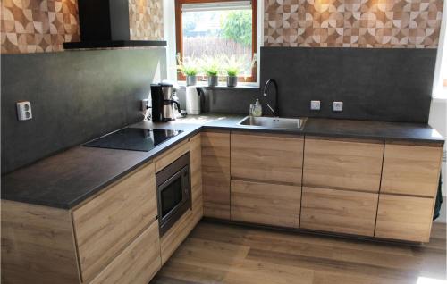 a kitchen with wooden cabinets and a sink at Amazing Home In Grou With Wifi in Grou