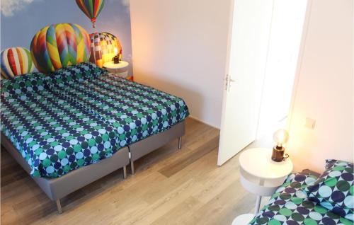 a bedroom with a bed with a blue and green bedspread at Amazing Home In Grou With Wifi in Grou