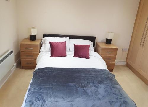 1 dormitorio con 1 cama grande y 2 mesitas de noche en Ballycotton Holiday Apartment No 6 en Ballycotton