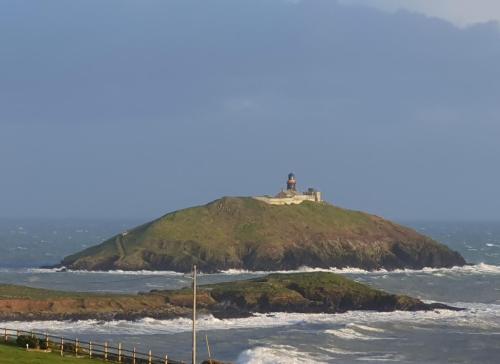 a lighthouse on an island in the ocean at Ballycotton Holiday Apartment No 6 by Trident Holiday Homes in Ballycotton
