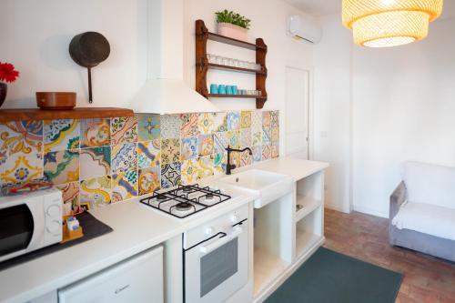 a kitchen with a stove top oven next to a sink at Casa d’autore siciliana in Milan