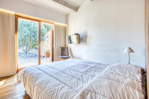 Un dormitorio con una cama grande y una ventana en Villa Stella, en Lumio