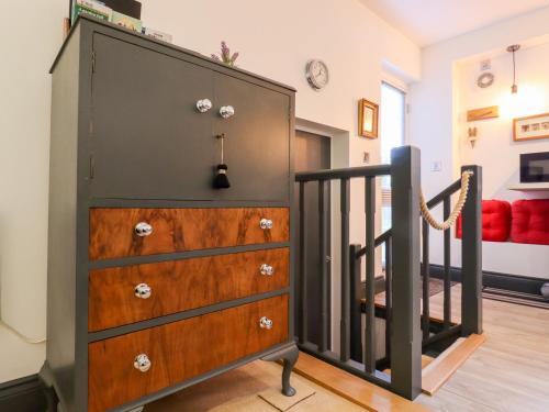 a chest of drawers in a room with a staircase at Paddock View in Maidstone