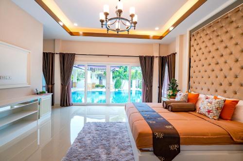 een slaapkamer met een groot bed en een groot raam bij Silverlake Oasis : Pool Villa in Na Jomtien