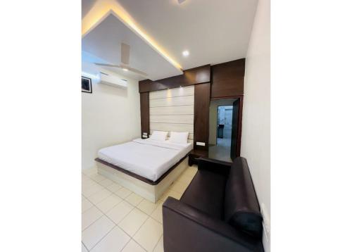 1 dormitorio con 1 cama y 1 sofá en Ritumbhara Hotel & Resort, en Alwar