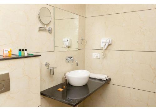 a bathroom with a sink and a mirror at Ritumbhara Hotel & Resort in Alwar