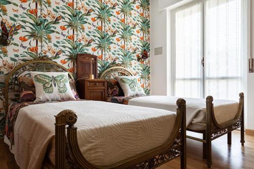 1 dormitorio con 2 camas y papel pintado con motivos florales en Ghe Sem Morazzone B&B, en Gazzada