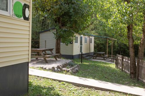 a campsite with two benches and a picnic table at Camping Alta Ribagorça in El Pont de Suert