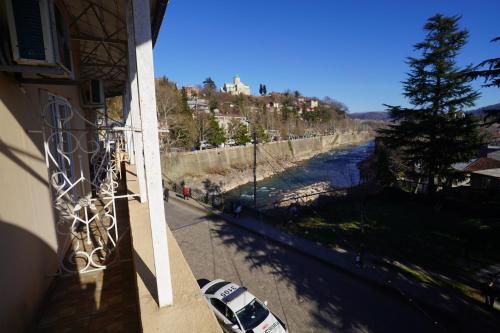 a balcony of a building with cars parked next to a river at imperator 1 Hotel in Kutaisi