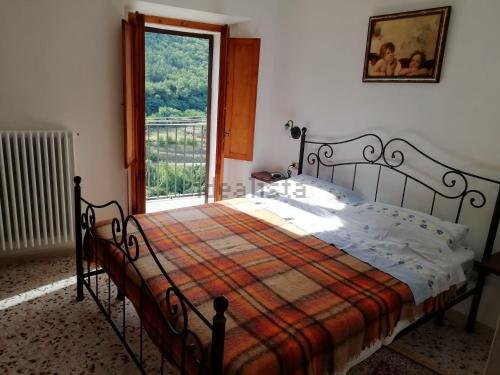 1 dormitorio con 1 cama con manta y ventana en Casa nel borgo nella natura en Pettorano sul Gizio