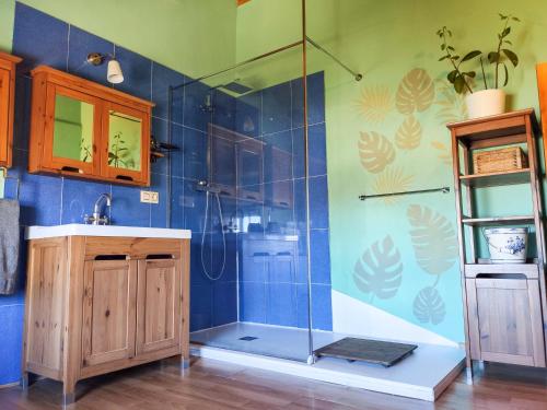 a bathroom with a shower with blue tiles at Casa Rural Tozolosolobos in Otero de Bodas