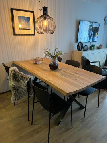 une table à manger avec des chaises et un éclairage dans l'établissement Appartement Ut & Thus, Resort Amelander Kaap, à Hollum