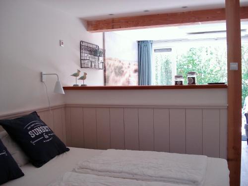 a bedroom with a bed in front of a window at Strandstudio Cato, vlakbij zee! in Callantsoog