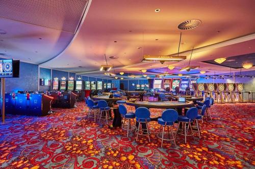 um casino com mesas e cadeiras e muitas slot machines em Maier Pension em Bayerisch Eisenstein