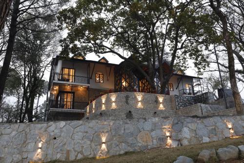 a house on top of a stone wall at Infinitea Dakbunglow Palampur in Pālampur