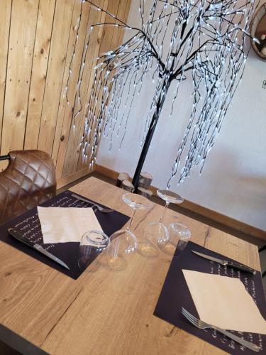 a wooden table with glasses and a tree on it at Les Jolis Coeurs in Thiéfosse