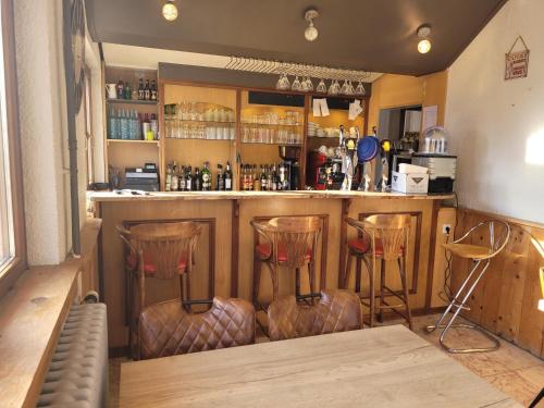 a bar with three stools in a room at Les Jolis Coeurs in Thiéfosse