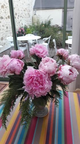 um vaso cheio de flores cor-de-rosa sobre uma mesa em Le Beau Verger em Le Mans