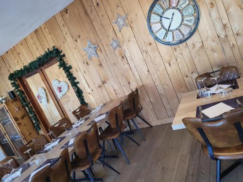 a room with tables and a clock on the wall at Les Jolis Coeurs in Thiéfosse