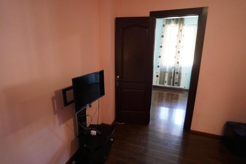 a living room with a television and a door at imperator 1 Hotel in Kutaisi