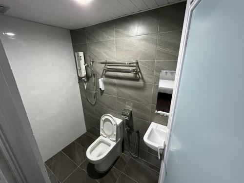 uma casa de banho com um WC e um lavatório em OU INN Cameron Highlands ,Ferm Nyonya Restaurant em Tanah Rata
