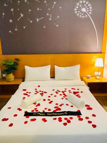 a bed with a bunch of red flowers on it at Dzulstudio(Muslim) Nova Highland in Brinchang