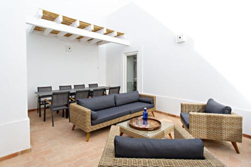 a living room with couches and a table and chairs at Amarela 17 in Tavira