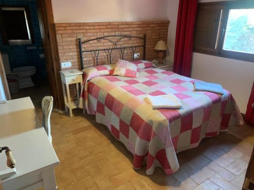 a bedroom with a bed with a checkered blanket at Casa Rural Los Robles de Acebo II in Acebo