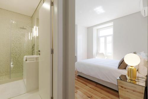 a bedroom with a bed and a bathroom with a shower at Apartamento Andrade in Lisbon