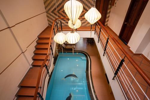 an indoor swimming pool in a house with lights at Hoa My II Hotel - Hoianese Old Town Hotel in Hoi An