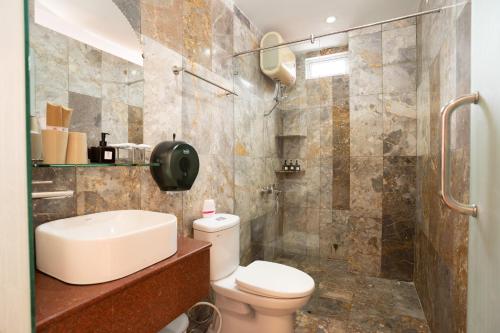 y baño con aseo, lavabo y ducha. en Hoa My II Hotel, en Hoi An