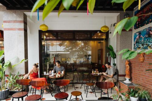 a group of people sitting at tables in a restaurant at Hoa My II Hotel in Hoi An