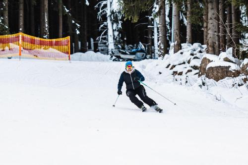 a person is skiing down a snow covered slope at Kazalnica Family&Conference Resort in Karpacz