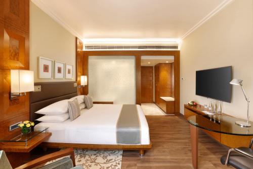 a hotel room with a bed and a television at Hyatt Regency Delhi in New Delhi