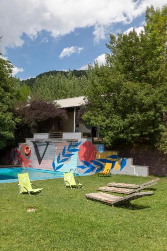 a yard with chairs and a wall with a mural at Camping Alta Ribagorça in El Pont de Suert