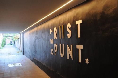 a sign on the side of a wall with the words trust fund at Het Rustpunt in Ghent