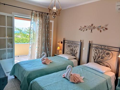 two beds in a room with swans on them at Villa Melenia in Almiros Beach
