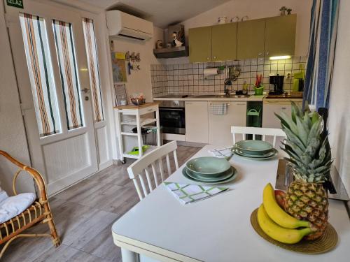 una cocina con una mesa con plátanos y una piña. en Apartments Rina, en Rovinj