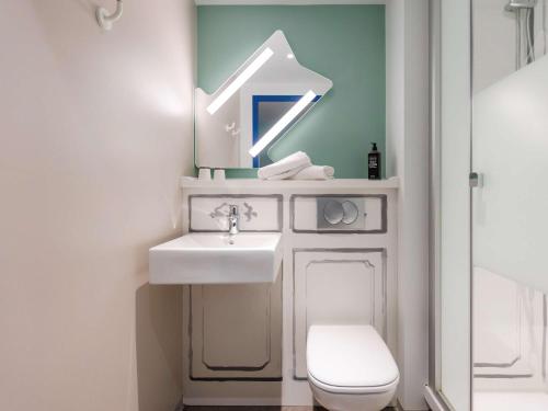 ein Badezimmer mit einem Waschbecken, einem WC und einem Spiegel in der Unterkunft ibis budget Albertville in Gilly-sur-Isère
