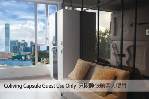 a living room with a couch and a large window at Harbour Hella Inn in Hong Kong
