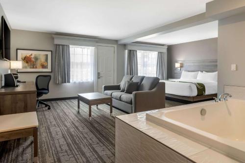 - une chambre d'hôtel avec un lit et une baignoire dans l'établissement Quality Inn Amsterdam Fredericton, à Fredericton
