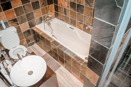 a bathroom with a toilet and a tub and a sink at Private luxurious 3 bedroom complete house in Bloemfontein