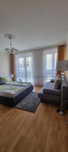 ハイドゥソボスローにあるM&M Luxus Apartmanのベッド2台とランプ付きの広い客室です。