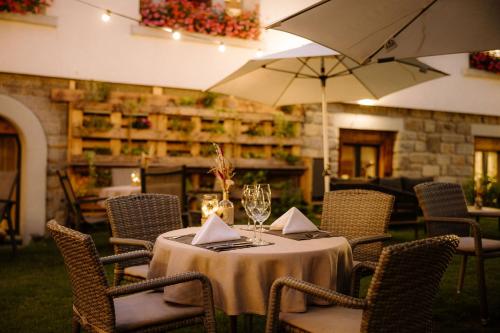 ツェルマットにあるAlpine Hotel Perrenのレストランのテーブルと椅子、傘