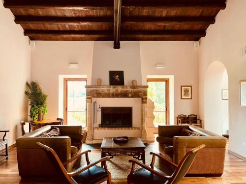 sala de estar con muebles de cuero y chimenea en Agriturismo Casale Montebello, en Monteleone di Spoleto