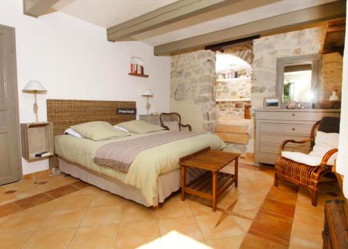 a bedroom with a large bed and a chair at Le miau in Vercoiran